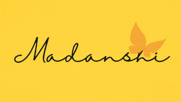 A square graphic with a solid yellow background, featuring the word 'Madanshi' in black cursive script and a stylized orange butterfly integrated into the lettering.